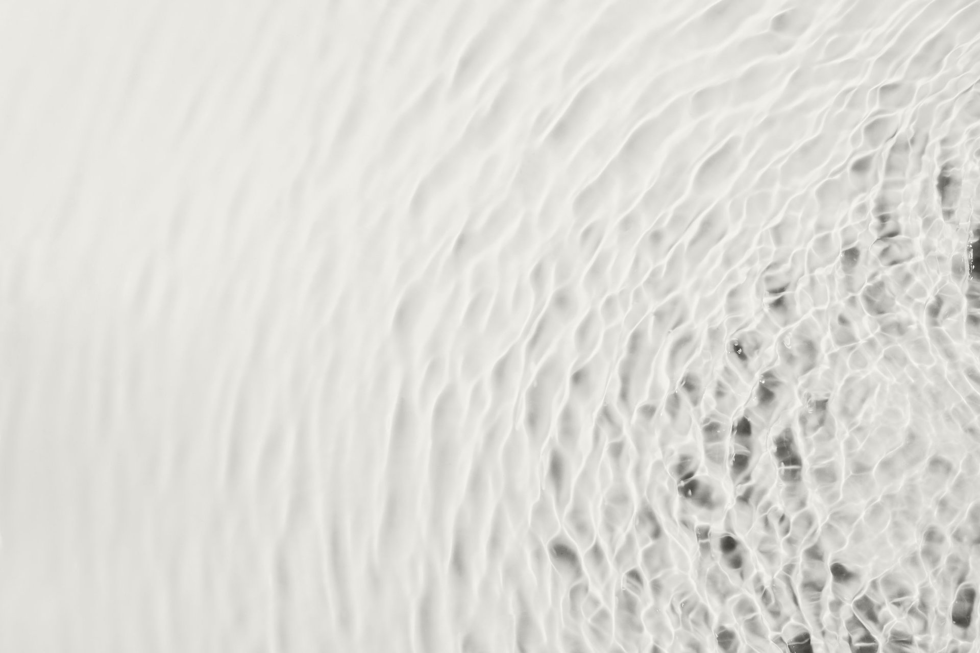 Water liquid surface showing light ripples and creating a clean, abstract texture