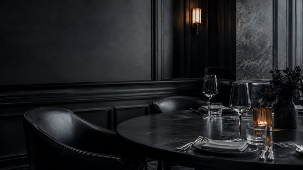 Elegant dining table setup in a dark, sophisticated interior with glassware, cutlery, and soft lighting accents.